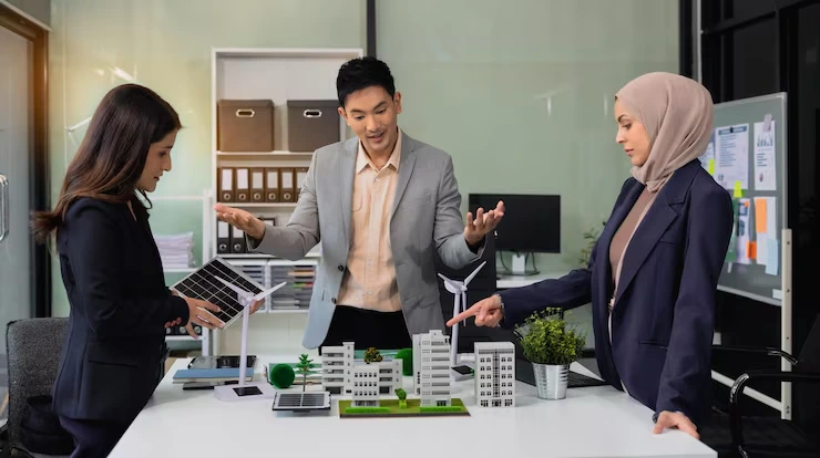 Property sourcing team presenting building models and development plans to potential investor in office