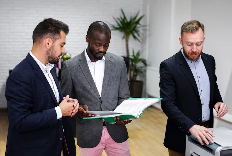 Business professionals reviewing legal compliance documents and contracts in office meeting