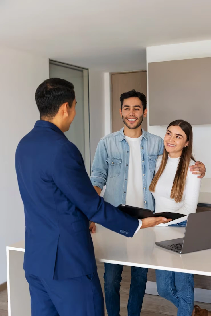 Property advisor presenting HMO investment opportunity to young couple in modern apartment viewing