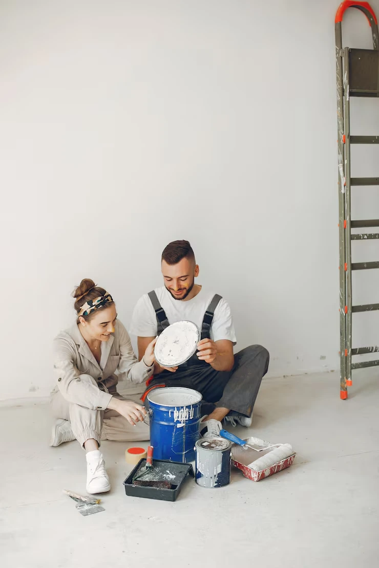 Renovation team preparing paint and supplies for property refurbishment work with ladder and paint buckets