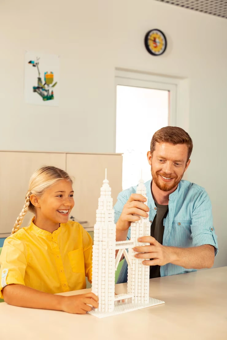 Father and daughter building white tower model together at kitchen table in bright home setting